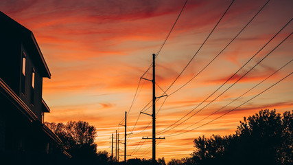 Power Lines Silhouette Against A Beautiful Sunset Sky