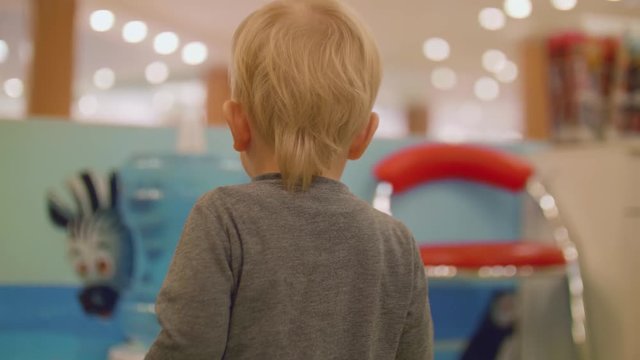 Back view of blond toddler walking ahead