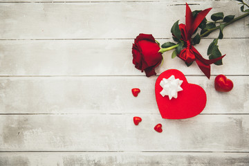 Gift box and red rose on wooden background. Valentines concept