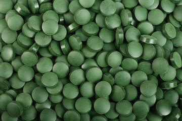 heap of Spirulina tablets algae nutritional supplement as a background close up top view. Flat lay
