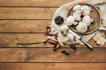 Champignon mushrooms on a wooden cutting board.