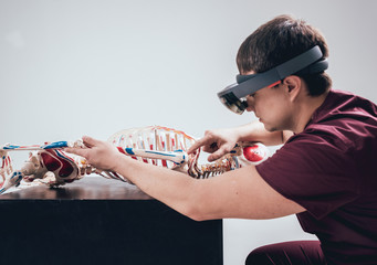Doctor uses augmented reality goggles to exam human skeleton
