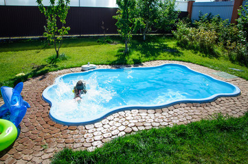 Little fun girl is swimming pool