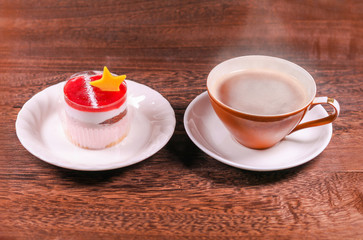 Cup of black coffee and Cake with jelly cream on wooden background with copy space .