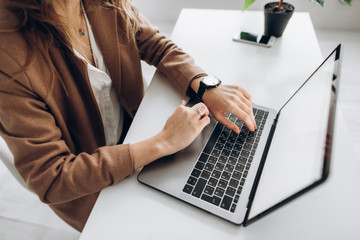 Woman typing on the laptop. White blank laptop screen with space for text
