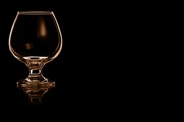 En empty glass for spirits with fire reflection.