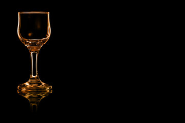 En empty glass of liqueur or cocktail sour with fire reflection.