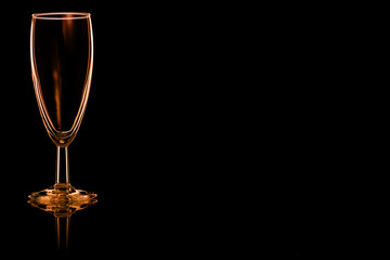 Empty champagne glass with fire reflection.