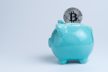 Bitcoin on blue piggy bank as crypto digital banking or cyber savings concept