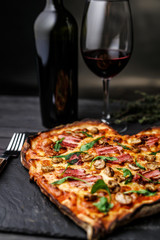 Pizza in the shape of heart with wine for St. Valentine's Day