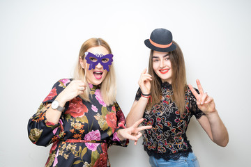 two young girls ladies pose photo booth plain background funny props