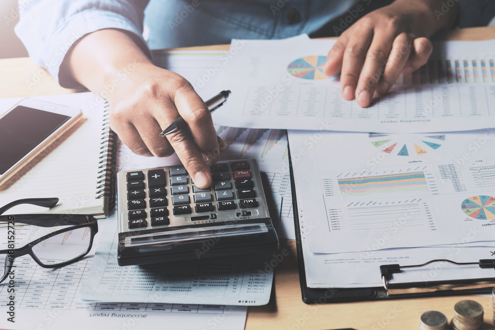 Poster close up business woman using calculator to calculate data document of finance accounting in office