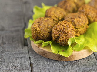 Freshly made falafel on a salad leaf on a cutting Board on a dark wooden table.