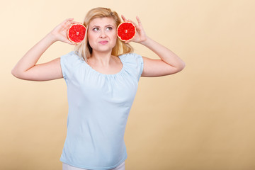 Happy smiling woman holding red grapefruit