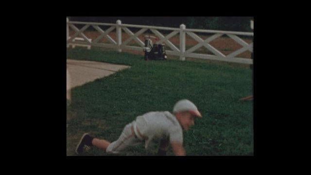 1959 Boy catches and throws baseball in baseball uniform
