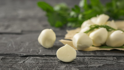 Freshly made mozzarella cheese with parsley on a wooden table. Selective focus.