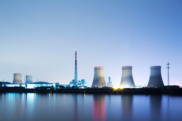 Obraz premium power plant near water at twilight