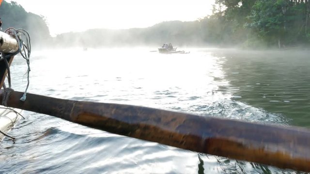 Close up view to the wooden boat paddle in bamboo rafting through fog floating over the lake in morning at Pang-ung, Mae Hong Son,Thailand