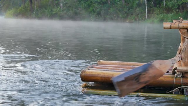 Close up view to the wooden boat paddle in bamboo rafting through fog floating over the lake in morning at Pang-ung, Mae Hong Son,Thailand