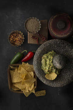 Overhead view of tortilla chip and guacamole in mortar and pestle