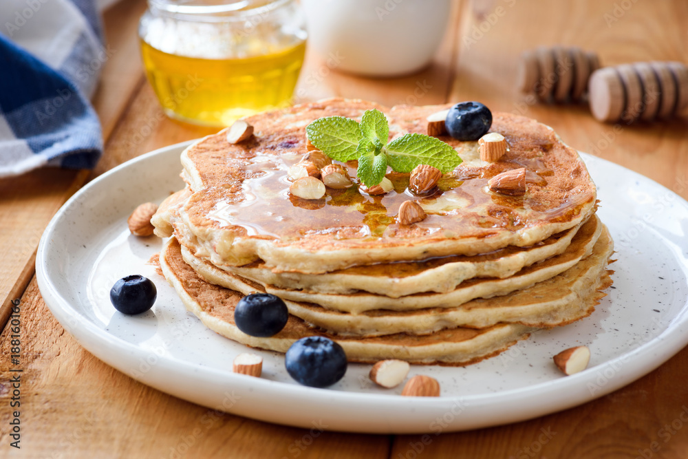 Wall mural Gluten free almond pancakes with blueberries and honey. Closeup view