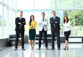 Happy business team with arms crossed at the office.