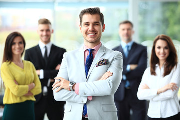 Happy business team with arms crossed at the office.