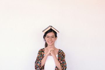 Fashion Portrait of Young cute asian woman wearing floral robe and holding a book