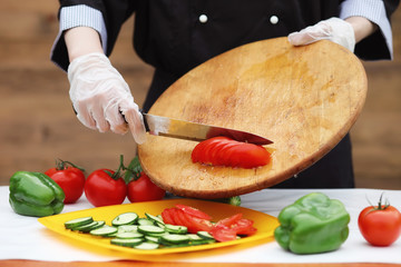 The cook cuts fresh farm vegetables