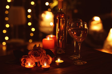 Beautiful romantic composition with candles, roses and glasses of wine in darkness