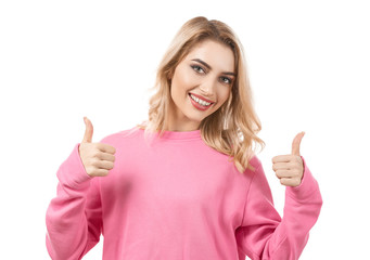 Young beautiful smiling woman showing thumbs-up gesture on white background