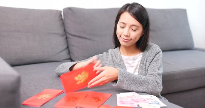 Woman putting money into red packet for chinese new year