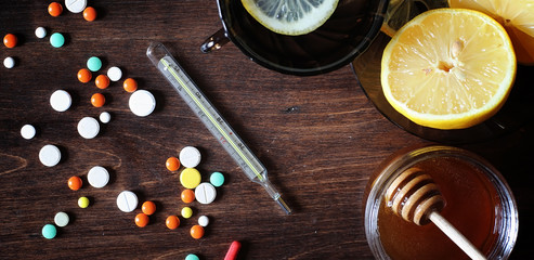 Fototapeta premium Drugs and pills on a wooden table. Various means to prevent cold