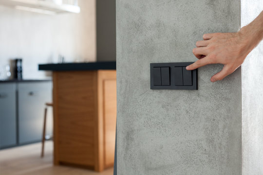 Close up of finger is turning on or off on light switch. Copy space.