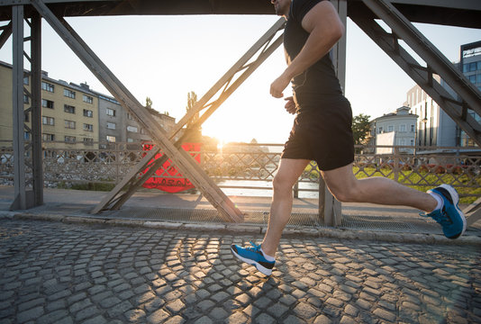 man jogging across the bridge at sunny morning