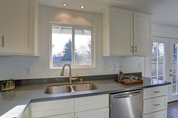 Light filled home interior features small compact kitchen