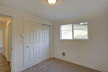 Empty room interior with built in closet and carpet floor.