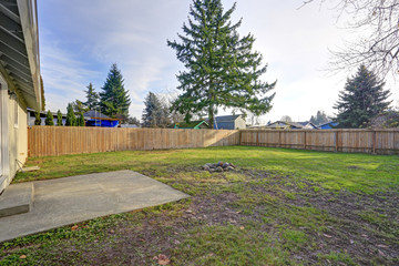 Spacious backyard with wooden fence and fire pit