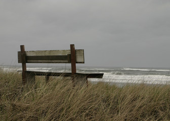 Fototapeta na wymiar A lonely bench on the ocean shore