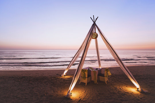 Honeymoon Dinner For Wedding Couple On The Beach In Luxurious Romantic Hotel, Beautiful Table For Two At Sunset