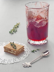 Strawberry jam in a glass upon gray background