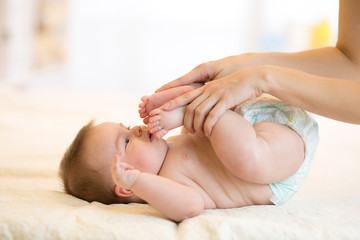 Obraz na płótnie Canvas Baby massage. Mother doing gymnastics kid.