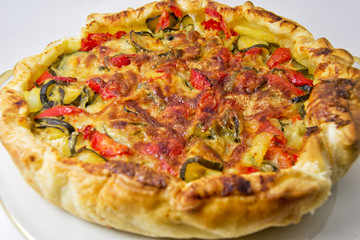 vegetables salad pie. quiche with zucchini, peppers, potatoes and puff pastry. for vegerarian cousine concept