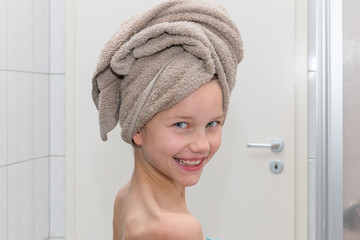 Ein Mädchen steht im Badezimmer und hat dasHandtuch zu einem Turban gewickelt