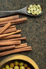 fresh coffee beans in wooden bowl with cinnamon for background