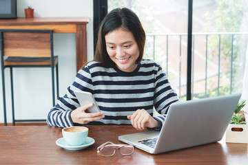 Fototapeta premium Asian woman take a break from using on laptop computer and drink hot coffee at cafe restaurant,Digital age lifestyle,Working outside office concept..