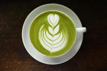 Papier Peint photo autocollant Theé Une tasse de thé vert matcha latte sur fond de bois