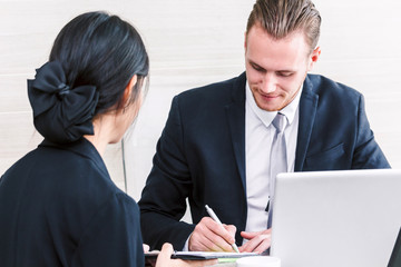 Fototapeta premium Businesswoman showing to the new contract for businessman signing contract document at office