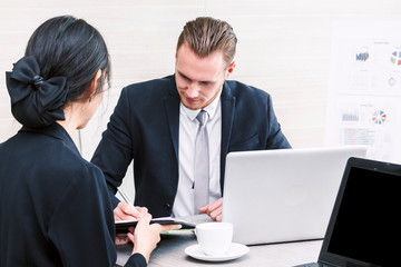 Fototapeta premium Businesswoman showing to the new contract for businessman signing contract document at office