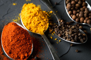 Various spices spoons on stone table.On dark concrete background.Herbs and spices on wooden table.
